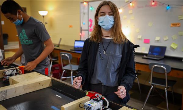 Girl smiles while holding robot